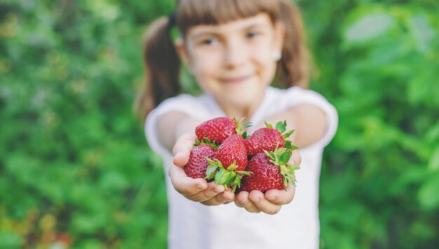 Foto retrato de una chica linda sosteniendo fresas