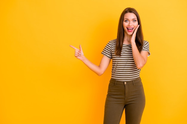 Retrato de chica loca sorprendida promotor punto dedo índice copia espacio recomendar anuncios de promoción de manera usar ropa moderna aislada sobre pared de color brillante