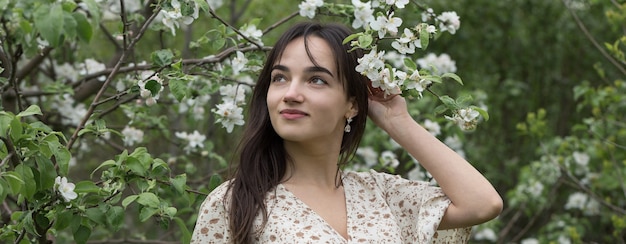 Retrato de una chica morena alegre positiva en un parque de primavera verde.