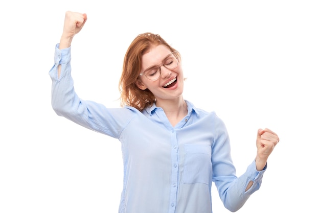 Retrato de una chica pelirroja positiva con camisa de negocios se regocija emocionalmente y se siente feliz aislada en un cartel publicitario de fondo blanco