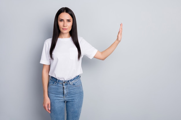 Retrato de chica de pelo liso contenido bastante estricto atractivo agradable agradable mostrando la señal de stop a un lado las medidas preventivas ncov sars aislado sobre fondo de color pastel gris claro