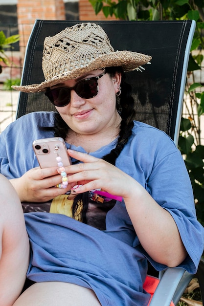 El retrato de una chica positiva y alegre usa un teléfono inteligente