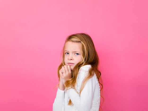 Foto retrato de una chica preocupada contra un fondo rosado