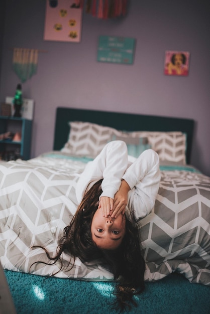 Foto retrato de una chica relajándose en la cama en casa