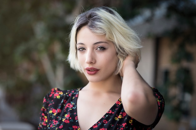 Retrato de una chica rubia en un parque de la ciudad