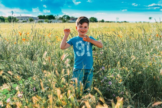 Foto retrato de una chica sonriente de pie en el campo