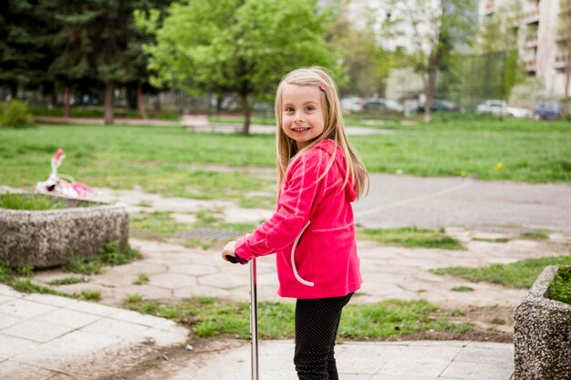 Retrato de una chica sonriente de pie en el parque