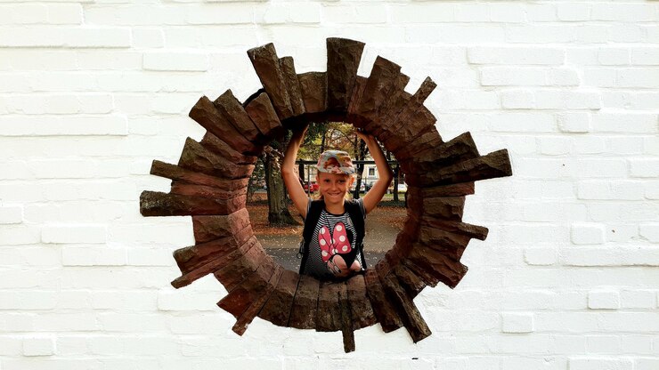 Foto retrato de una chica sonriente de pie en una ventana en círculo en la pared