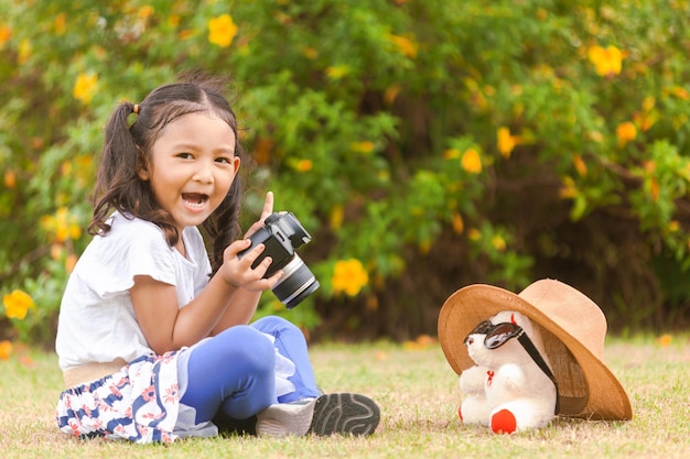 Foto retrato de una chica sonriente sentada al aire libre