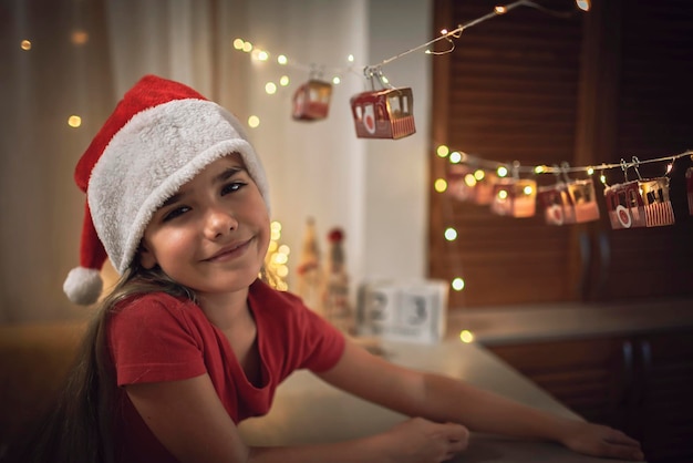 Foto retrato de una chica sonriente sentada en casa