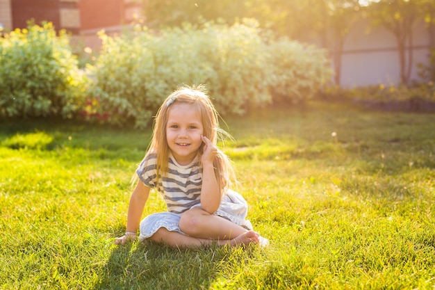 Retrato de una chica sonriente sentada en la hierba