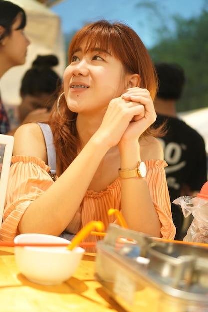 Foto retrato de una chica sonriente sentada en la mesa