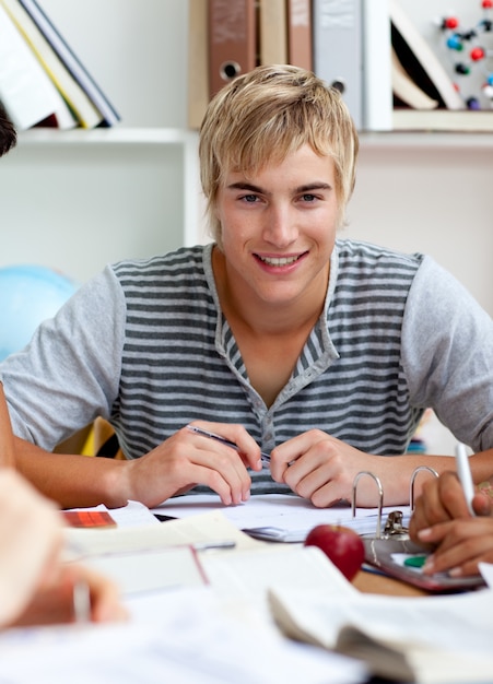 Retrato de un chico adolescente estudiando en la biblioteca