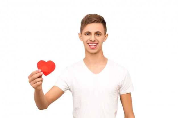 Retrato de un chico en una camiseta blanca sosteniendo un corazón, aislar
