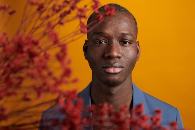 Retrato de un chico guapo africano posando en la cámara contra el fondo amarillo