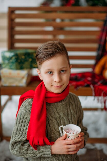 Retrato de chico guapo con bebida caliente en Navidad