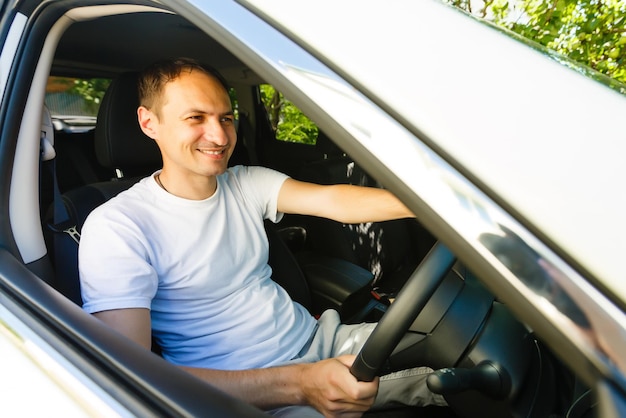 Foto retrato de un chico guapo conduciendo su coche