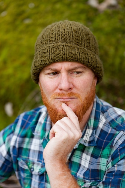 Retrato de un chico hipster pensando en el bosque