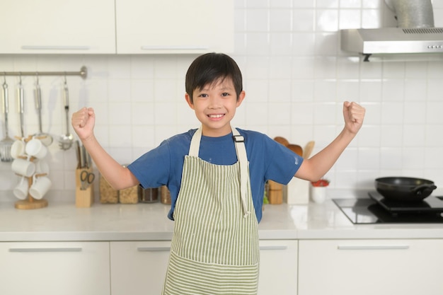 Retrato de chico inteligente sonriendo en la cocina de casa