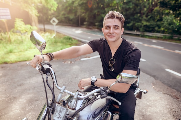 Foto retrato de un chico sentado en una motocicleta