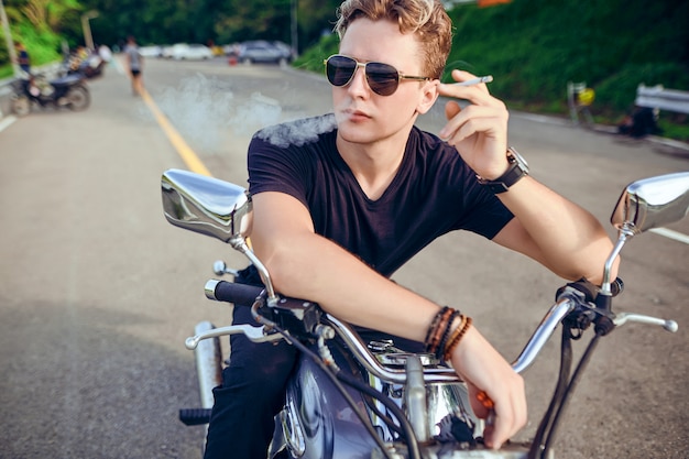 Retrato de un chico sentado en una motocicleta