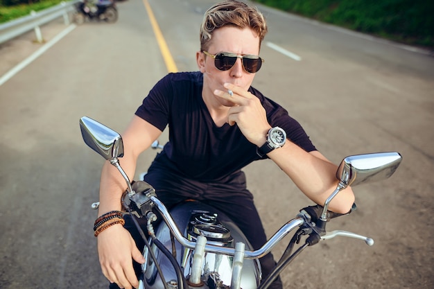 Foto retrato de un chico sentado en una motocicleta