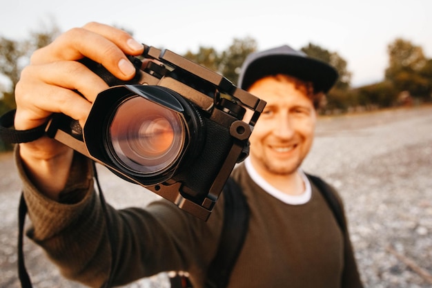 Retrato de un chico tomando una foto con una cámara profesional