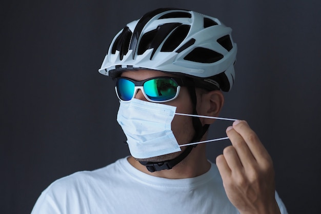 Retrato de un ciclista masculino en una máscara médica. Concepto Covid-19