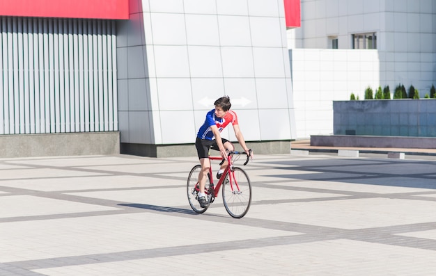 Retrato de un ciclista montando una ciudad en una bicicleta de carretera