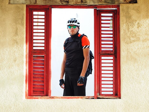 Retrato de ciclista en una vieja casa abandonada