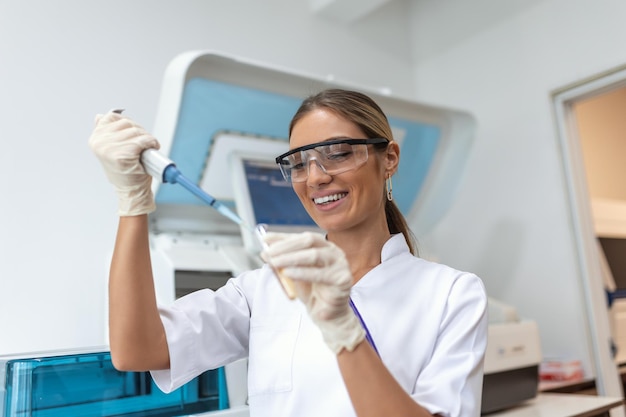 Retrato de una científica con una pipeta analiza un líquido para extraer el ADN y las moléculas en los tubos de ensayo en el laboratorio Concepto de investigación bioquímica medicina farmacéutica