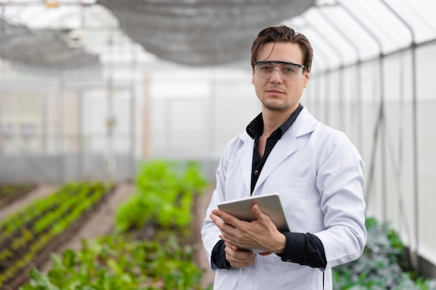 Retrato científico investigador masculino trabajador del personal que recopila información de la planta de estudio en la granja agrícola Concepto de ciencia agrícola