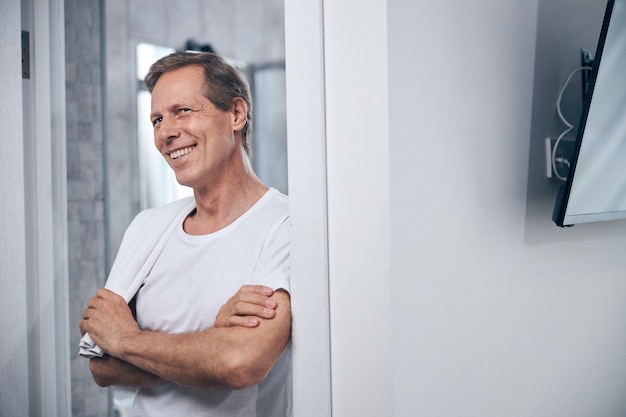 Retrato de cintura para arriba de un atractivo hombre con una toalla de baño colgando sobre su hombro