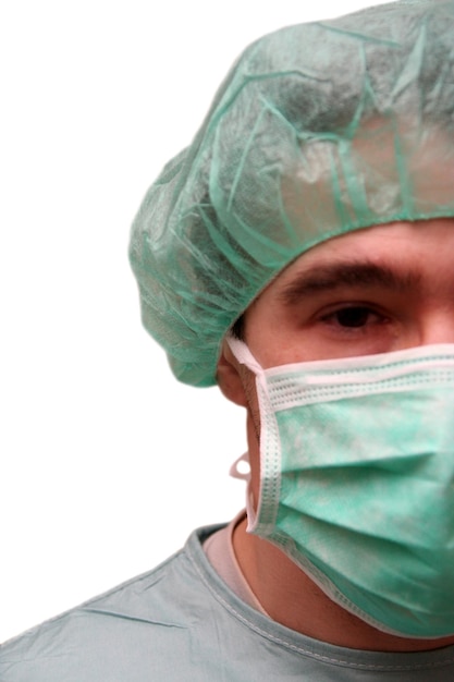 Foto retrato de un cirujano masculino con máscara quirúrgica y gorra sobre fondo blanco