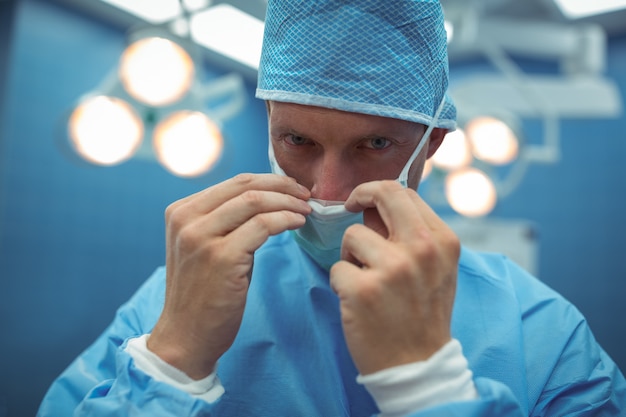 Foto retrato de cirujano masculino con máscara quirúrgica en quirófano