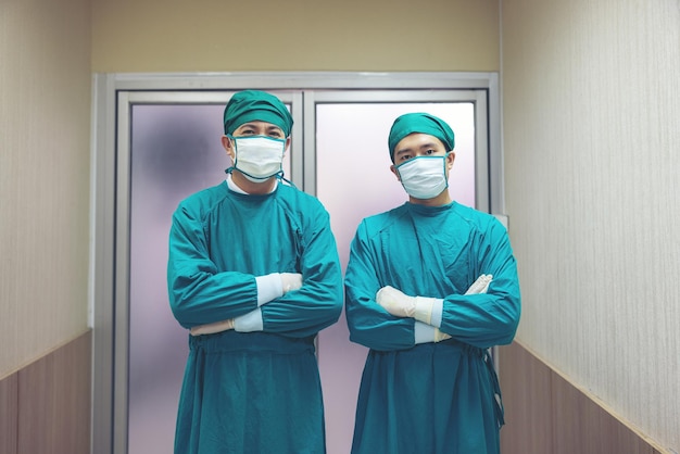 Retrato de un cirujano masculino en un quirófano con un equipo de médicos en el fondo