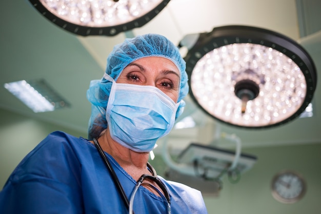 Foto retrato de cirujano de pie en la sala de operaciones