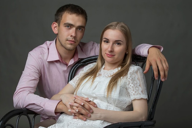 Retrato clásico de una mujer joven y un hombre sobre un fondo gris.