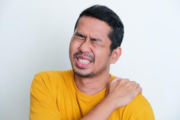 Foto el retrato de clausura de un hombre asiático adulto sufre dolor de hombro