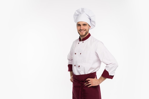 Retrato de cocinero chef guapo positivo en boina y traje blanco aislado sobre fondo blanco.