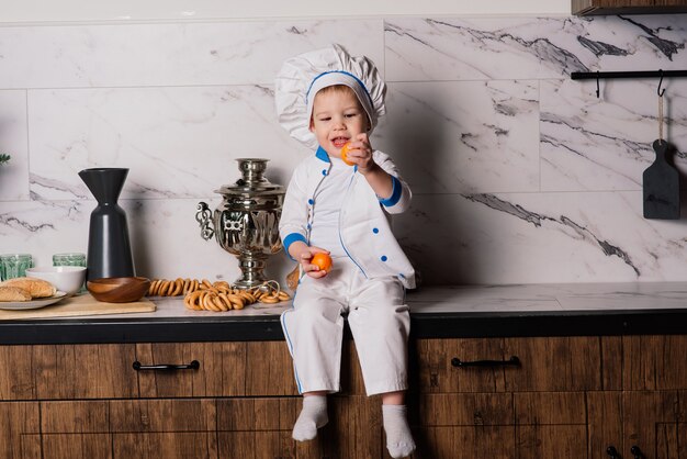 Retrato de un cocinero de niño pequeño con sartén en la cocina. Diferentes ocupaciones. Aislado sobre fondo blanco. Gemelos