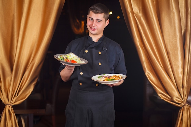 Retrato del cocinero de sexo masculino sonriente hermoso del cocinero en la situación uniforme