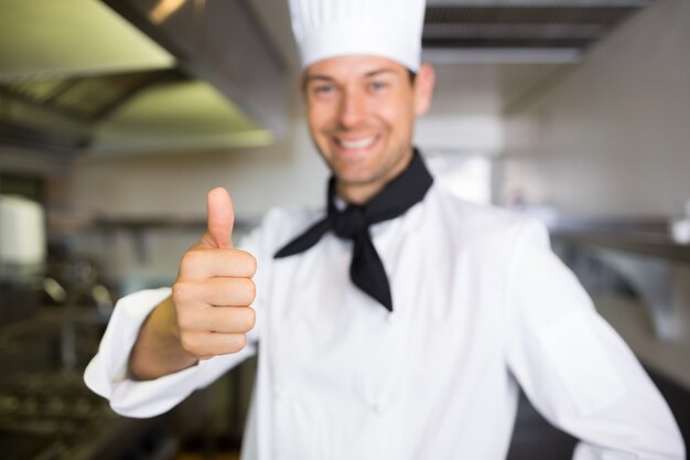 Foto retrato de un cocinero de sexo masculino sonriente que gesticula los pulgares para arriba