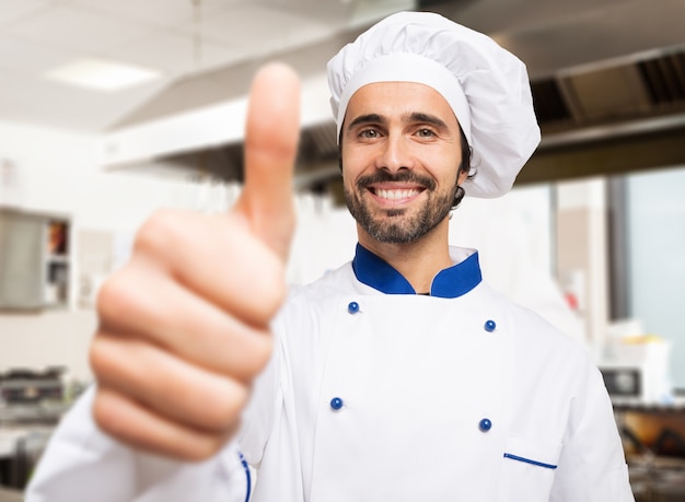 Retrato de un cocinero sonriente dando pulgares