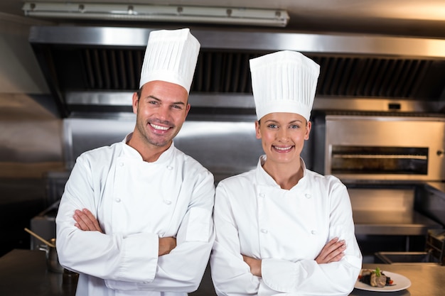 Retrato de cocineros felices de pie en la cocina