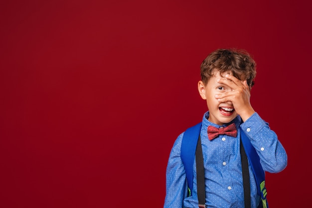 Retrato de un colegial que se cubrió el rostro con la mano