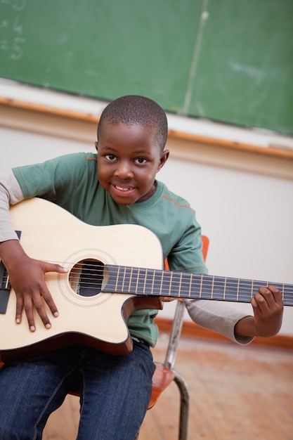 Retrato de un colegial tocando la guitarra