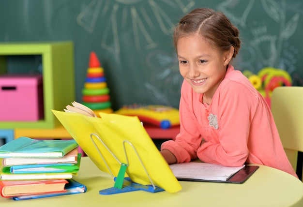 Retrato de colegiala haciendo la tarea en el aula