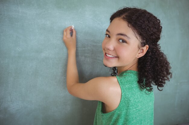 Retrato de colegiala pretendiendo ser maestra en el aula