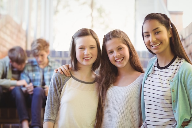 Retrato de colegialas sonrientes sentados en la escalera